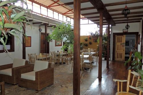 a dining room with tables and chairs and plants at La Estancia Hotel Boutique in Salamina