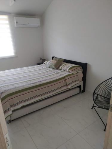 a bedroom with a bed in a white room at Hermosa casa en condominio campestre el peñon in Girardot
