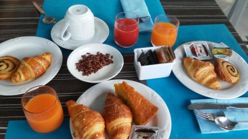 a blue table with plates of breakfast food and orange juice at Lady Hamilton B&B in Feletto
