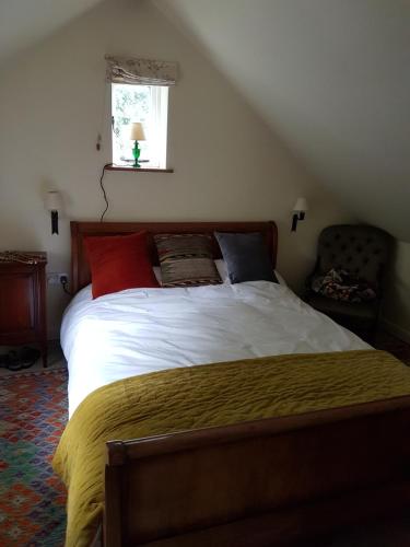 a bedroom with a bed with red and blue pillows at Baptist Cottage in Cheverell