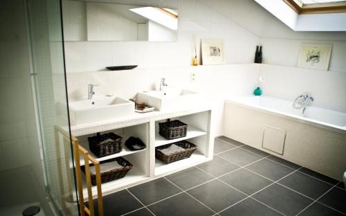 a bathroom with two sinks and two mirrors at B&B House Ninety in Brussels