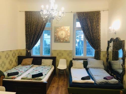 sypialnia z 2 łóżkami, kanapą i oknami w obiekcie Modern Classic on Kiraly w Budapeszcie