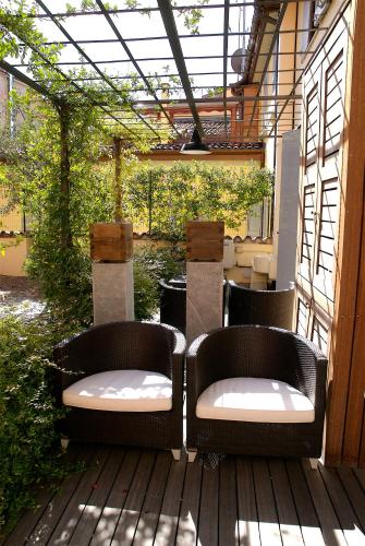 two wicker chairs sitting on a wooden deck at Hotel Metropolitan in Bologna