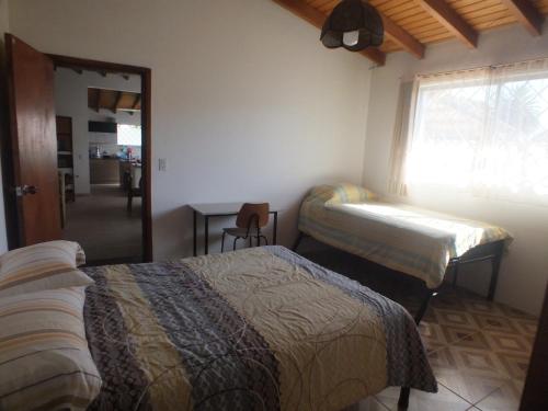 een slaapkamer met 2 bedden, een tafel en een raam bij Quito Eco Lodge Airport - B&B in Tababela