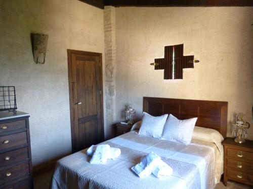 ein Schlafzimmer mit einem Bett und einem Kreuz an der Wand in der Unterkunft Casa Rural Castillo LA Iruela in La Iruela