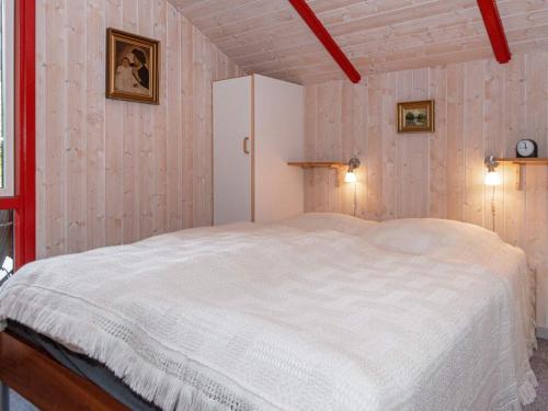 a bedroom with a white bed and a white cabinet at Holiday Home Lærkevej VI in Ebeltoft