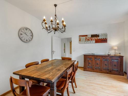 a dining room table with chairs and a clock on the wall at Apartment with private terrace in Velmede in Bestwig