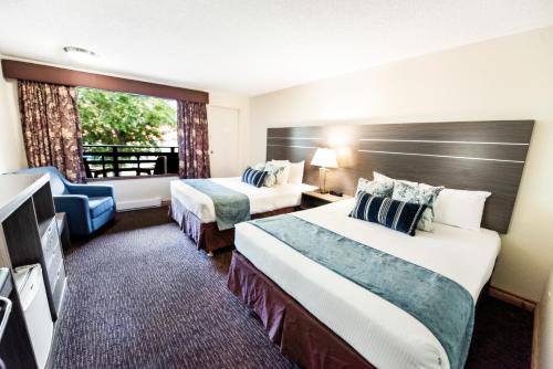 ein Hotelzimmer mit 2 Betten und einem Fenster in der Unterkunft Bayshore Inn & Spa in Waterton Park