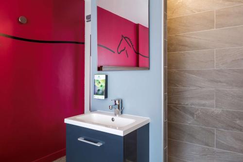 a bathroom with a sink and a pink wall at Sure Hotel by Best Western Argentan in Argentan