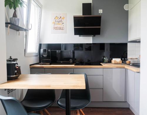 a kitchen with a wooden table and chairs at Rose Valley Apartment in Polanica-Zdrój