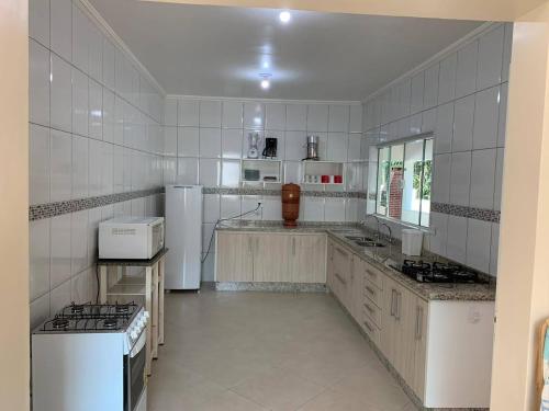 Una gran cocina blanca con electrodomésticos blancos. en Taipas Pousada e Camping en Iporanga