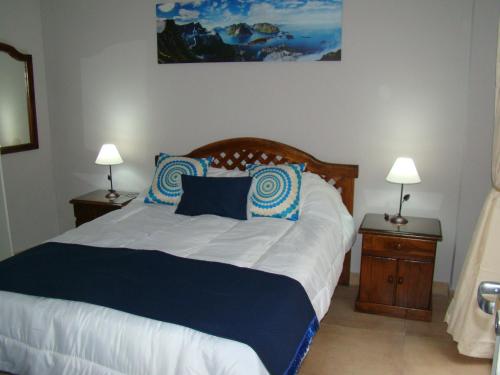una camera da letto con un grande letto con cuscini blu e bianchi di Mis Nietos a Barraquero
