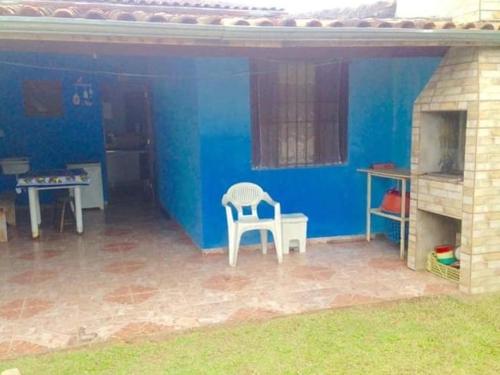 una casa blu con una sedia e un tavolo di Boracéia Beach a São Sebastião