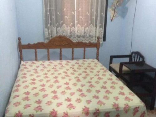 una camera da letto con un letto con copriletto floreale e una finestra di Boracéia Beach a São Sebastião