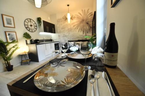 eine Flasche Wein und Gläser auf der Küchentheke in der Unterkunft ASSAS 7 - HYPERCENTRE HISTORIQUE DE DIJON in Dijon