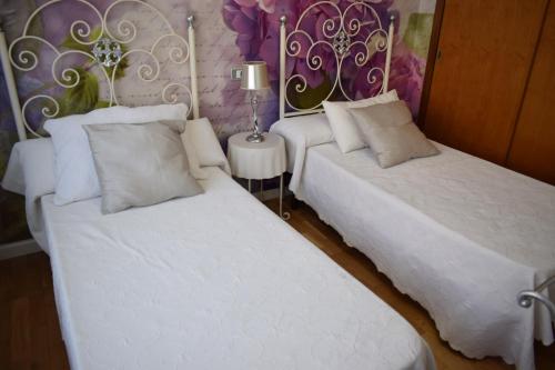 two beds sitting next to each other in a room at Alojamientos Villarias Murcia in Murcia