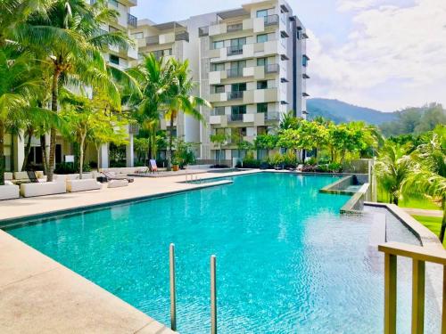 a swimming pool in front of a building at Beachfront Resort By The Sea, Batu Ferringhi in Batu Ferringhi