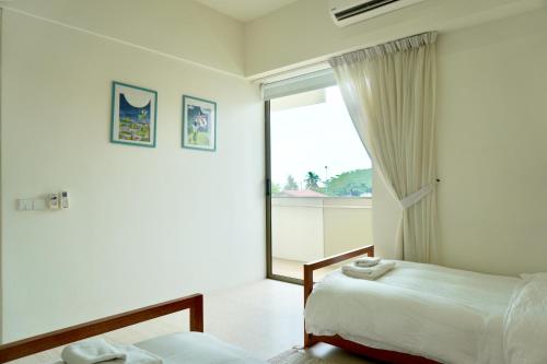 Un pat sau paturi într-o cameră la Beachfront Resort By The Sea, Batu Ferringhi