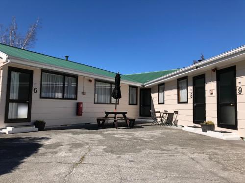 a building with a picnic table in front of it at Forest Peak Motel in Hanmer Springs