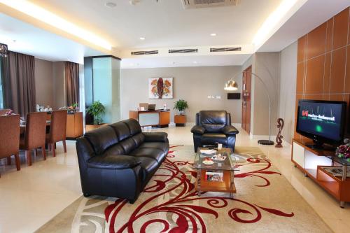 a living room with a couch and a tv at Swiss-Belhotel Kendari in Kendari