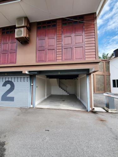 a garage with two red doors on a house at Little Kampung Studio in Teluk Intan