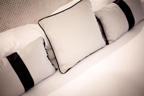 
a white bed with pillows and pillows on it at Gwesty'r Emlyn Hotel in Newcastle Emlyn
