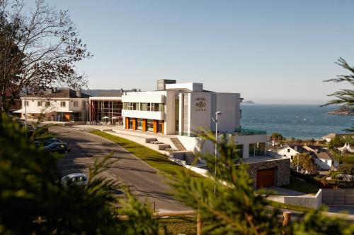a large white building with the ocean in the background at Hotel Ego in Viveiro