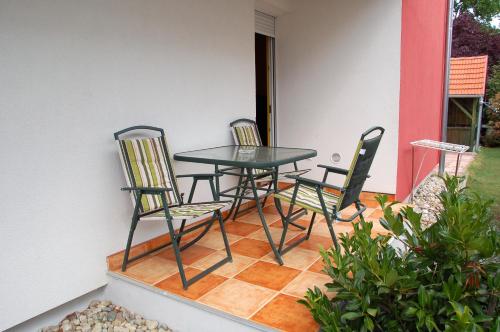 two chairs and a table on a patio at Laci Apartman in Zalakaros
