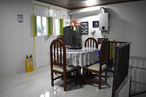 La cuisine est équipée d'une table, de chaises et d'un réfrigérateur. dans l'établissement Posada Dónde Cupeto, à Salento