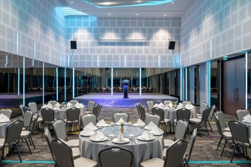 a banquet hall with tables and chairs and a stage at VELA Dhi Udon Thani in Udon Thani
