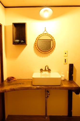a bathroom with a sink and a mirror on the wall at Guesthouse SHIGI in Nakatsugawa