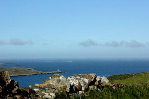 a lighthouse on a hillside overlooking a body of water at Clifden Bay Lodge in Clifden