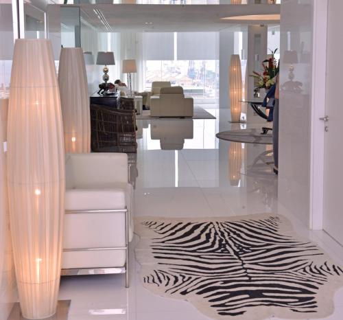 a living room with a zebra print rug and a chair and table at Hotel Presidente Luanda in Luanda