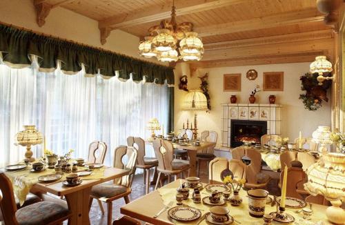 a dining room with tables and chairs and a fireplace at Pension Buschmühle in Ohorn