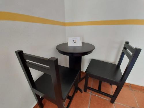 a black table and two chairs with a sign on it at Nicol-Haa in Izamal