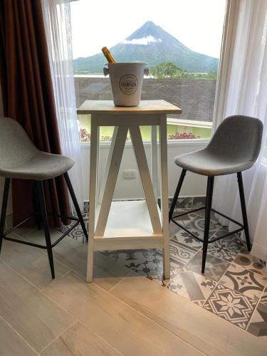 a table and two chairs in front of a window at Hotel Arenal Vista Lodge in Fortuna