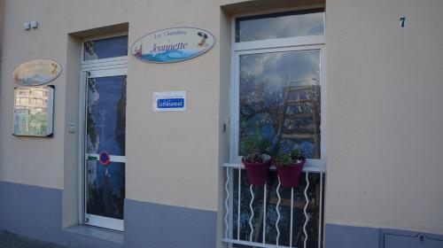 a building with two potted plants on a balcony at Les Chambres de Jeannette in Marseille