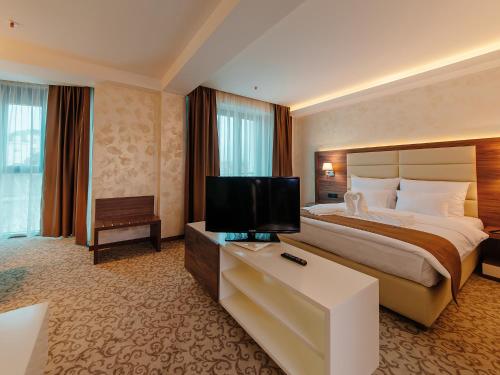 a hotel room with a bed and a flat screen tv at Hotel New Star in Podgorica