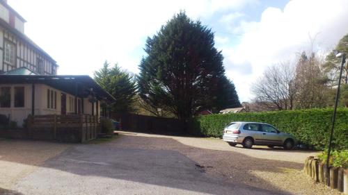 a car parked in a driveway next to a house at The Burley Inn in Burley