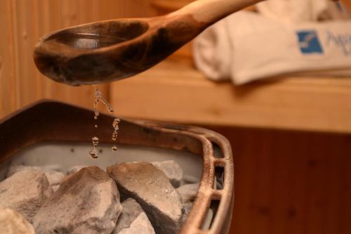 a wooden spoon pouring water into a basket of rocks at Aegean Houses in Kos Town