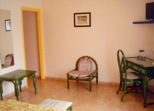 a living room with chairs and a table and a chair at Motel des Bruyères in Lamotte-Beuvron