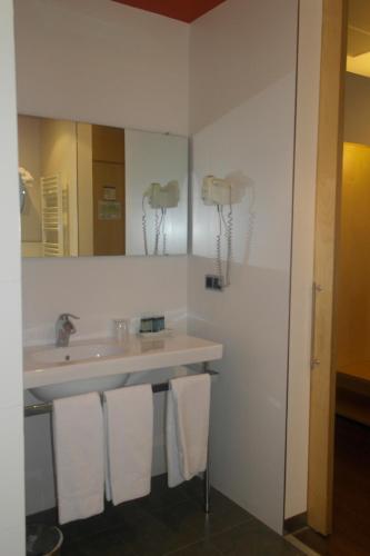 a bathroom with a sink and a mirror and towels at Gobeo Park in Vitoria-Gasteiz