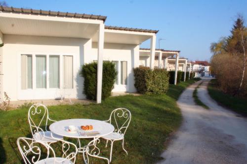 una mesa y sillas en el césped junto a una casa en Motel des Bruyères en Lamotte-Beuvron