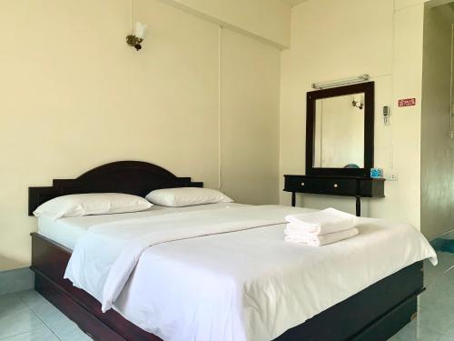 two beds in a hotel room with a mirror at J-2 Court in Songkhla