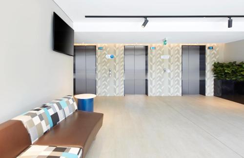 a waiting room with a row of elevators in a building at Holiday Inn Express Sydney Airport by IHG in Sydney