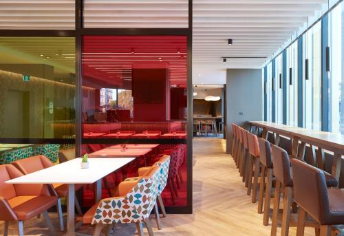 a dining room with tables and chairs in a restaurant at Holiday Inn Express Sydney Airport by IHG in Sydney