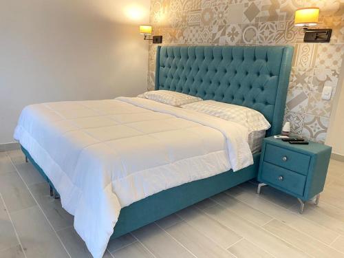 een slaapkamer met een groot bed met een blauw hoofdeinde bij Hotel Arenal Vista Lodge in Fortuna