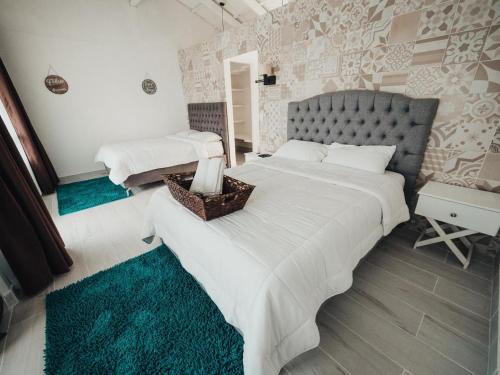 een slaapkamer met 2 bedden en witte lakens bij Hotel Arenal Vista Lodge in Fortuna