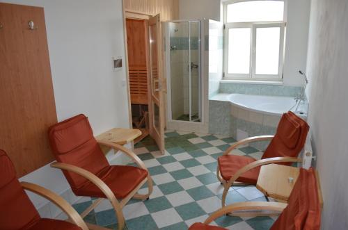 a bathroom with chairs and a shower and a tub at Hotel Na Statku in Nepřevázka