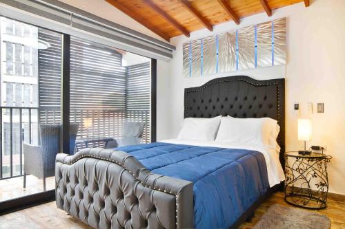 a bedroom with a large bed with a blue blanket at Miracle in Medellín